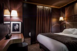 a hotel room with a bed and a black and white photo at Hotel Armoni Paris in Paris