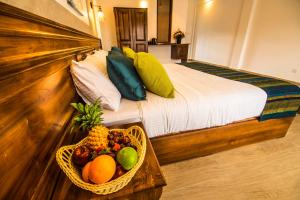 a bedroom with a bed with a basket of fruit at Seasons Villa - Nuwara Eliya in Nuwara Eliya