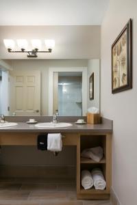 baño con 2 lavabos y espejo grande en Carlisle Inn Sarasota en Sarasota