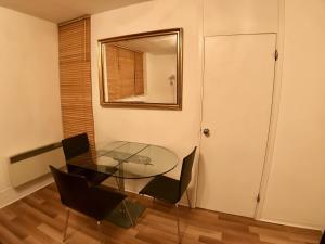 a glass table and chairs in a room with a mirror at Central apartment 5 mins Putney tube station in London
