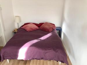a bed with a purple blanket and two pillows at Central apartment 5 mins Putney tube station in London
