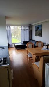 sala de estar con mesa y sofá en Corona Laboris en Colijnsplaat