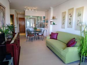 アレナレス・デル・ソルにあるView Bay Arenales Del Solのリビングルーム(緑のソファ、テーブル付)