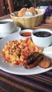 a plate of food with eggs and meat on a table at Hotel Real Plaza in Antigua Guatemala