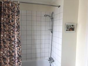 a bathroom with a shower and a white tile wall at Maison du Photographe in Bic +23 photos
