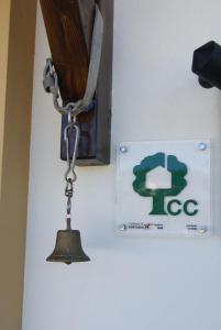 una campana colgando en una pared junto a una señal en Casa De Santo Antão - Turismo Rural en Padrões
