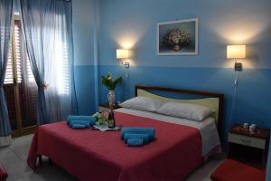 1 dormitorio con 1 cama grande y paredes azules en B&B La casa di Luigi, en Giardini Naxos