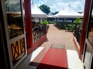 an open door of a restaurant with tables and white tents at Savannah Paradise Hotel in Makindu