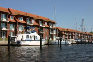 a boat docked in a marina next to buildings at Lagunenstadt Ueckermünde AG in Ueckermünde