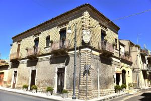 un bâtiment avec une horloge sur son côté dans l'établissement Affittacamere Sestiere Santa Caterina, à Grammichele