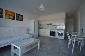 a kitchen and living room with a couch and a table at Krasas Beach Flats in Larnaka
