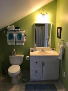 La salle de bains est pourvue de toilettes, d'un lavabo et d'un miroir. dans l'établissement Lavender Bay, à Barnstable