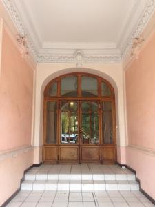 Una gran puerta de madera en una habitación con suelo de baldosa. en Hermitagethermale, en Royat