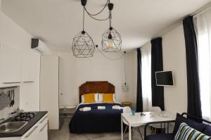 a bedroom with a bed and a table and a kitchen at Anita & Garibaldi in Marsala