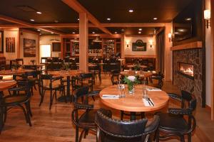 a restaurant with wooden tables and chairs and a fireplace at Harbour House Hotel in Ganges