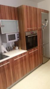 a kitchen with wooden cabinets and a stainless steel refrigerator at Alina in Giżycko