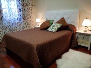 um quarto com uma cama com duas almofadas em Casa Cordieira em Combarro