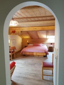 una camera con letto e soffitto in legno di B&B Bucaneve a Vigo di Fassa