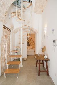 a living room with a table and a spiral staircase at Manidibianco Apulian Relaxing Stay in Turi