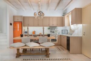 a kitchen with wooden cabinets and a wooden table at Villa Nausithoe in Logaras