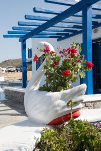 a statue of a swan next to a bouquet of flowers at Mykonos Welcome Suites in Ano Mera