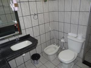 La salle de bains est pourvue de toilettes blanches et d'un lavabo. dans l'établissement Pousada Vó Otília, à Juazeiro do Norte