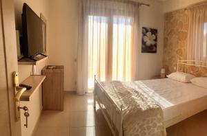a bedroom with a bed and a flat screen tv at Anastasia Villas in Siviri