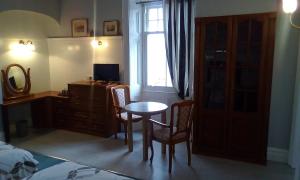 a bedroom with a table and chairs and a window at Tower Hotel in Talgarth