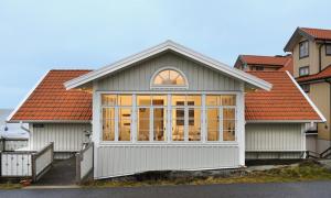 una pequeña casa con una gran ventana delante de ella en Logi & Bastu, en Käringön