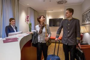 a man and a woman standing in a hotel room with luggage at Hotel Monte Cenci in Rome