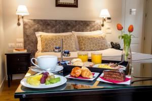 a tray of breakfast foods on a table in a bedroom at Hotel Monte Cenci in Rome