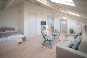 a bedroom with a bed and a couch and chairs at Comonfive Apartments in Como