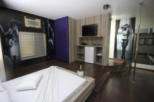 a hotel room with a bed and a tv and a room at Snob Motel (Adult Only) in Belo Horizonte