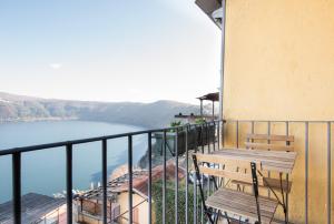 a balcony with two benches and a view of the water at Casa Albalonga in Castel Gandolfo