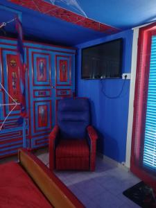 a blue room with a red chair and a tv at Affitto breve Spider-man house in Catania