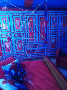 sypialnia z łóżkiem i ścianą z niebieskimi światłami w obiekcie Affitto breve Spider-man house w Katanii