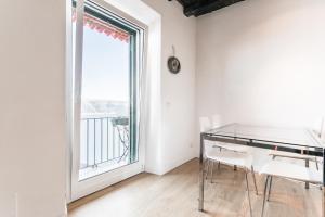 a dining room with a glass table and a large window at Casa Albalonga in Castel Gandolfo