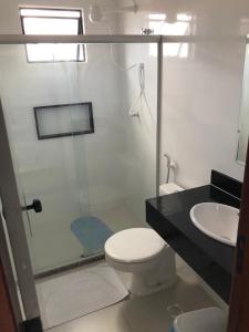 a bathroom with a shower and a toilet and a sink at Hotel Kalilândia in Feira de Santana