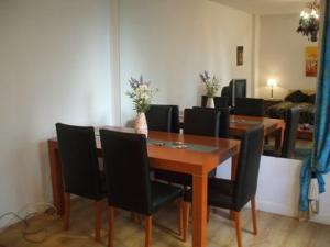 comedor con mesa de madera y sillas negras en Oro Plaza Apartamentos en Buenos Aires