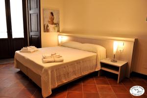 1 dormitorio con 1 cama con toallas en La Dimora del Musicante HomeGallery, en Viggiano