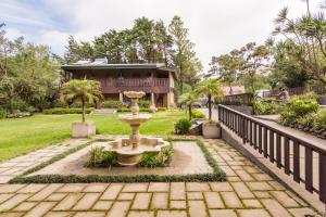 a garden with a fountain in front of a house at Monteverde Country Lodge - Costa Rica in Monteverde Costa Rica