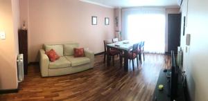 uma sala de estar com um sofá e uma mesa de jantar em Departamento Salta Capital em Salta