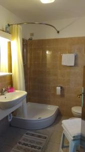 a bathroom with a tub and a sink and a toilet at CO.RI. Appartamenti in Menaggio