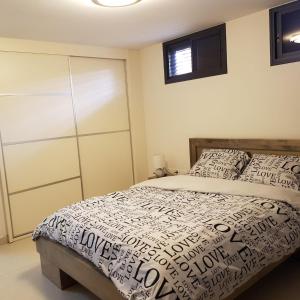 een slaapkamer met een bed met een wit dekbed bij mi casa es su casa in Ashkelon
