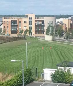 a large green field in front of a building at Dublin Corporate Apartment in Lucan