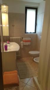 メナッジョにあるCO.RI. Appartamenti Dependanceのバスルーム(洗面台、トイレ付)、窓が備わります。