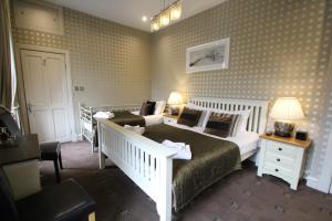 a hotel room with a bed, chair, and nightstand at The Sandaig in Edinburgh