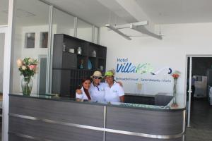 tres mujeres de pie detrás de un mostrador en una habitación en Villa Kite, en Santa Marianita