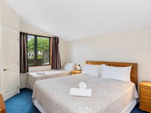 Un pat sau paturi într-o cameră la Boatshed Motel Apartments