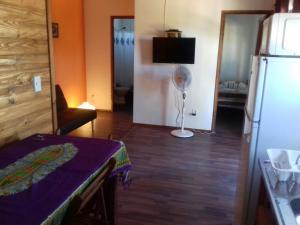 a kitchen with a table and a refrigerator in a room at Sonidos del Mar in Punta Del Diablo